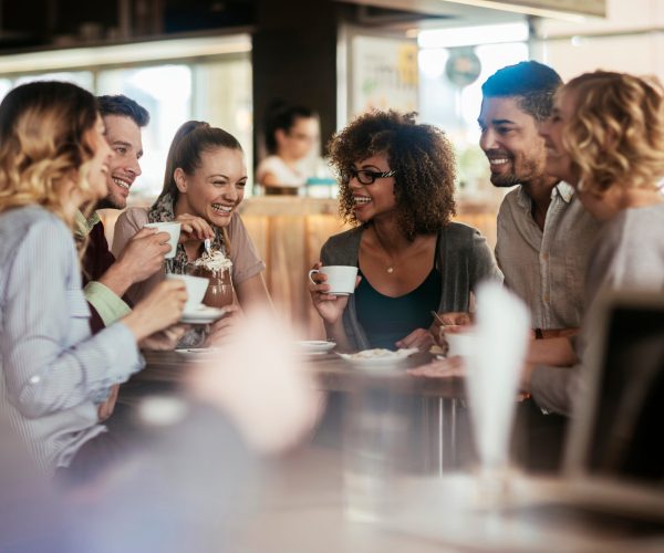 Young friends sitting in cafe having a great time